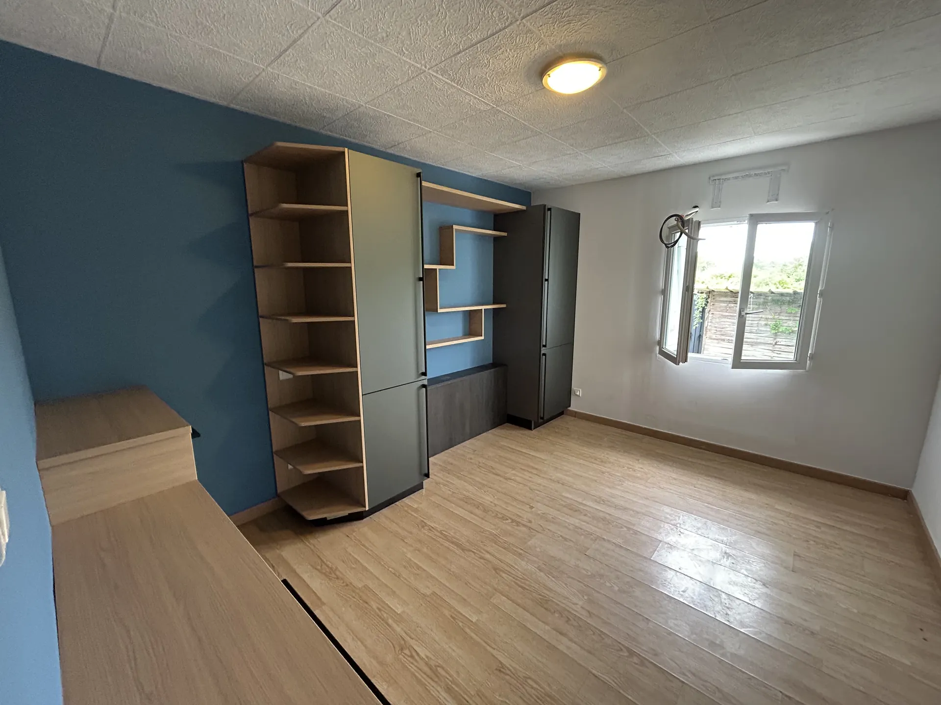Le même dressing vu dans la chambre, ajusté au volume de la pièce